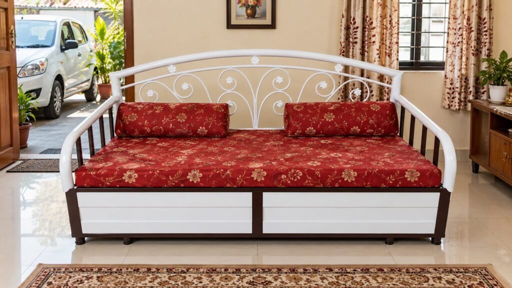 Red floral metal sofa cum bed by Tuba Furniture, Pune